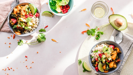 A table displaying two bowls of food, containing a colorful assortment of vegetables and fruits, providing a healthy and balanced meal.