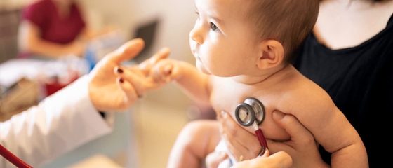 A doctor carefully examines a baby during a medical check-up.