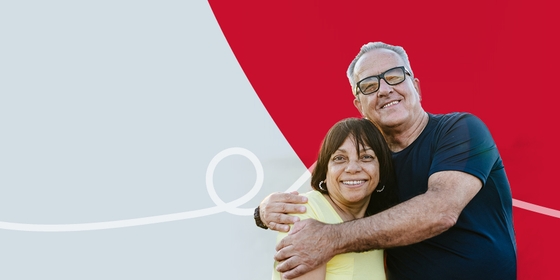 A couple embracing affectionately on a background of red and grey