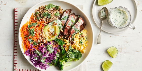 A plate of food featuring a colorful assortment of vegetables, a fresh salad, and a drizzle of dressing.
